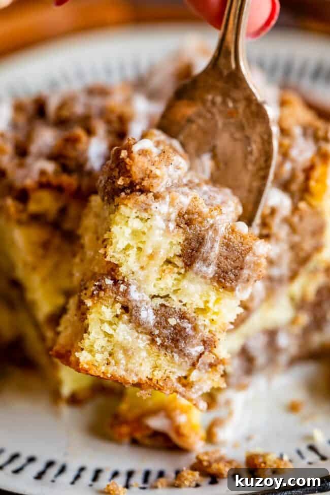 Coffee cake slice with glaze Slice of coffee cake with streusel and glaze on a fork.