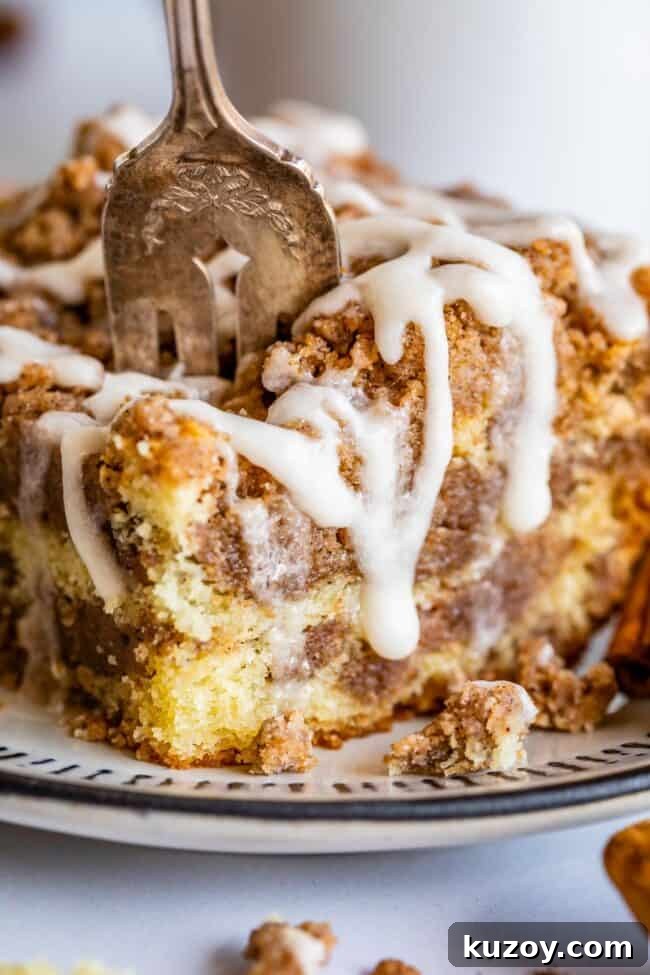 Cinnamon Streusel Coffee Cake cinnamon streusel coffee cake on a plate with a fork stuck in it.