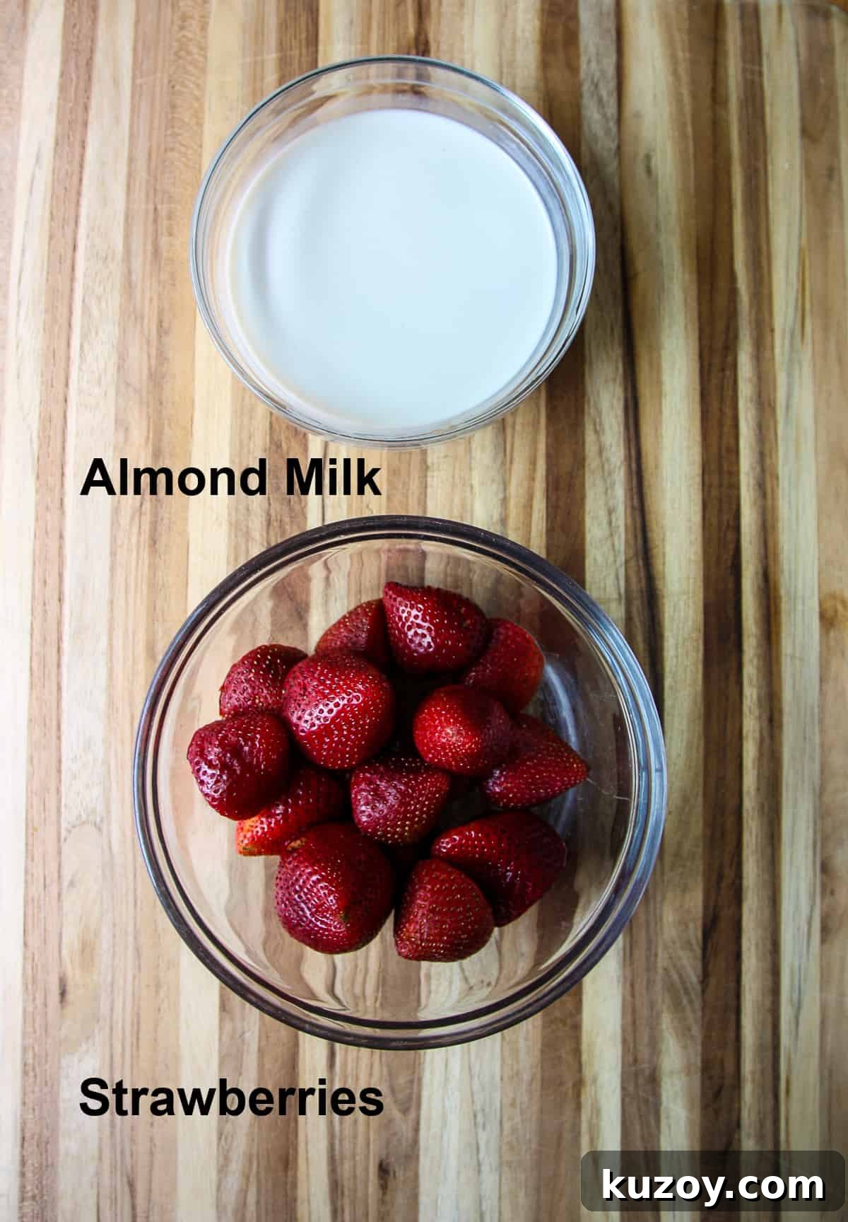 Sugar-Free Strawberry Popsicles Recipe — Fresh & Fruity 4 The two ingredients used to make strawberry popsicles; almond milk and strawberries, in glass bowls.