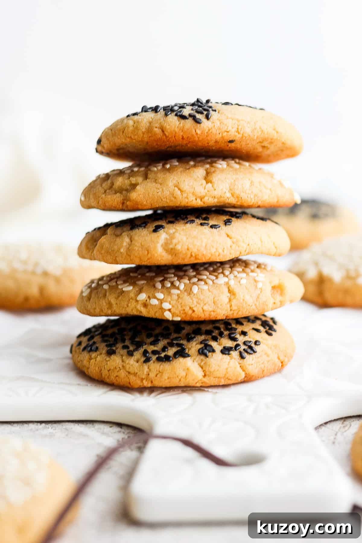 Chewy Tahini Cookies Recipe with Golden Sesame Flavor 13 a stack of cookies with sesame seeds on top.