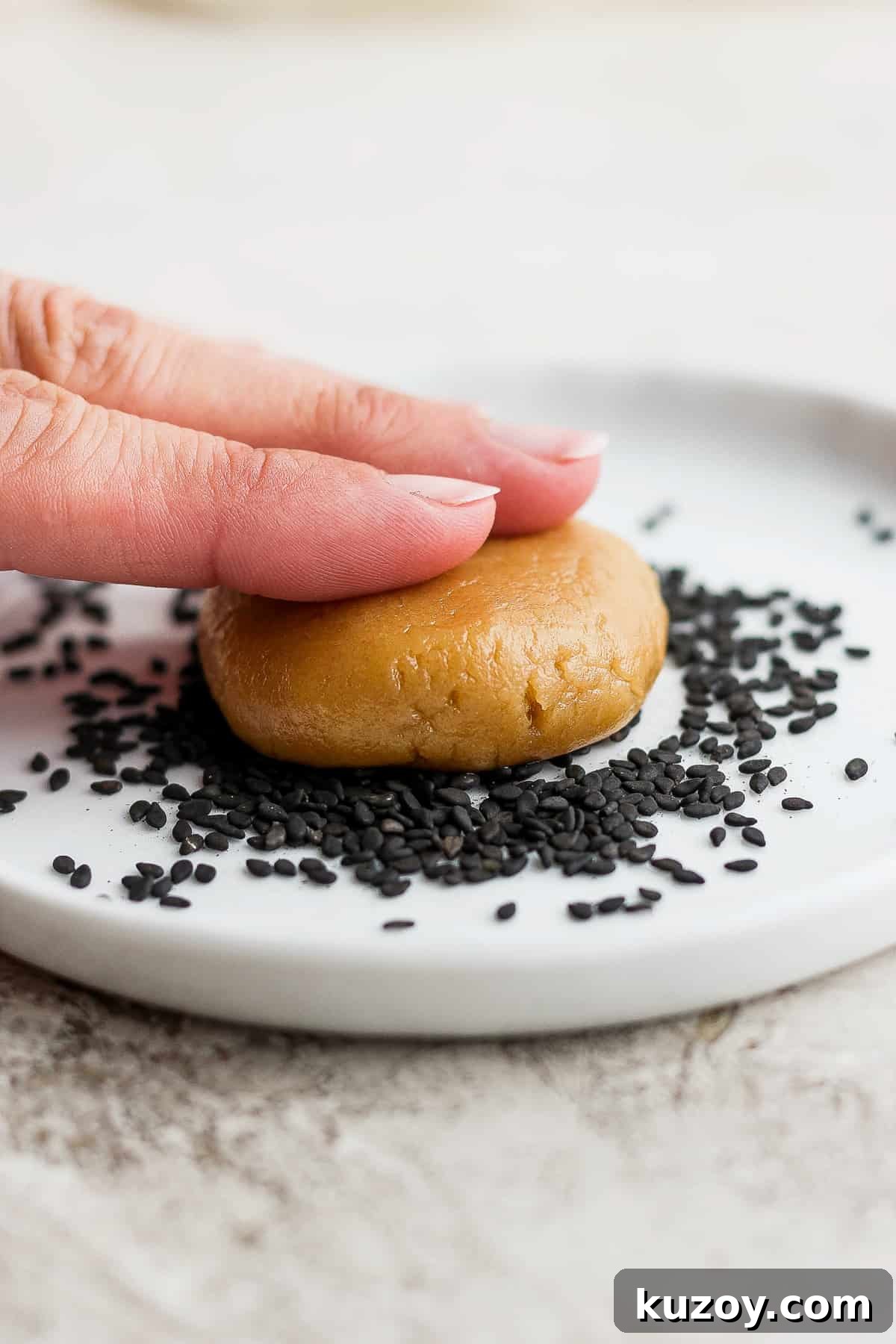 Chewy Tahini Cookies Recipe with Golden Sesame Flavor 10 a hand is holding a cookie with sesame seeds on it.