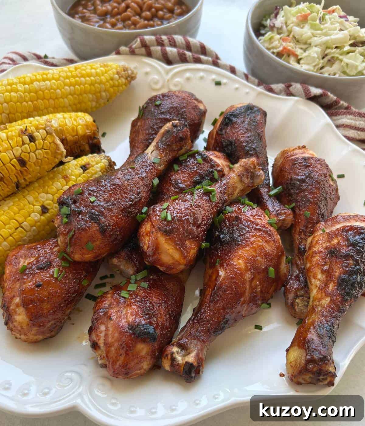 Crispy Oven-Baked BBQ Chicken Drumsticks Recipe 8 BBQ Chicken drumsticks with corn on platter.