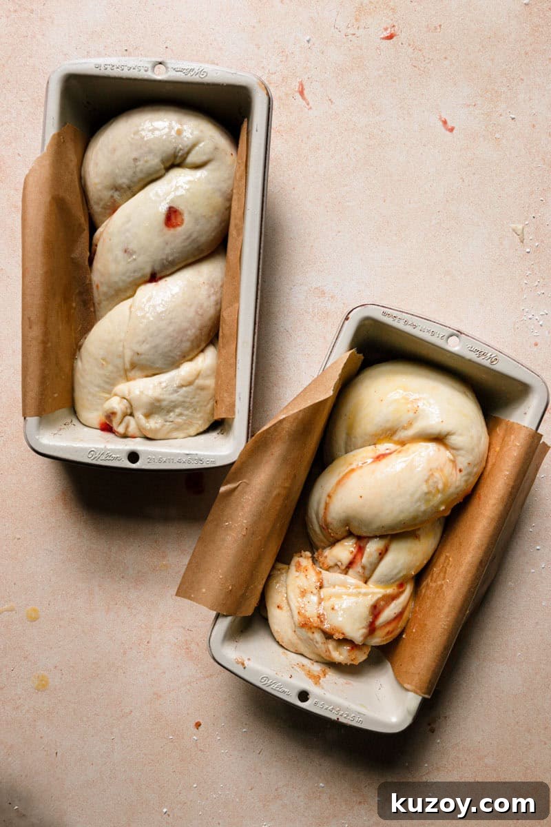 Two loaf pans filled with Raw babka dough.
