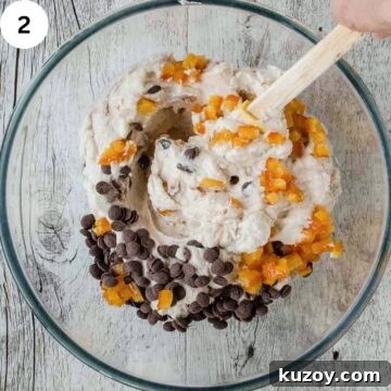 How to Make Classic Cannoli Filling at Home 5 Chocolate and chopped candied orange being stirred into a creamy mixture.