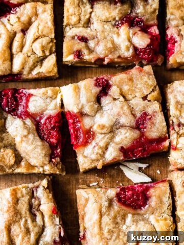 Raspberry white chocolate blondies on a wooden cutting board.