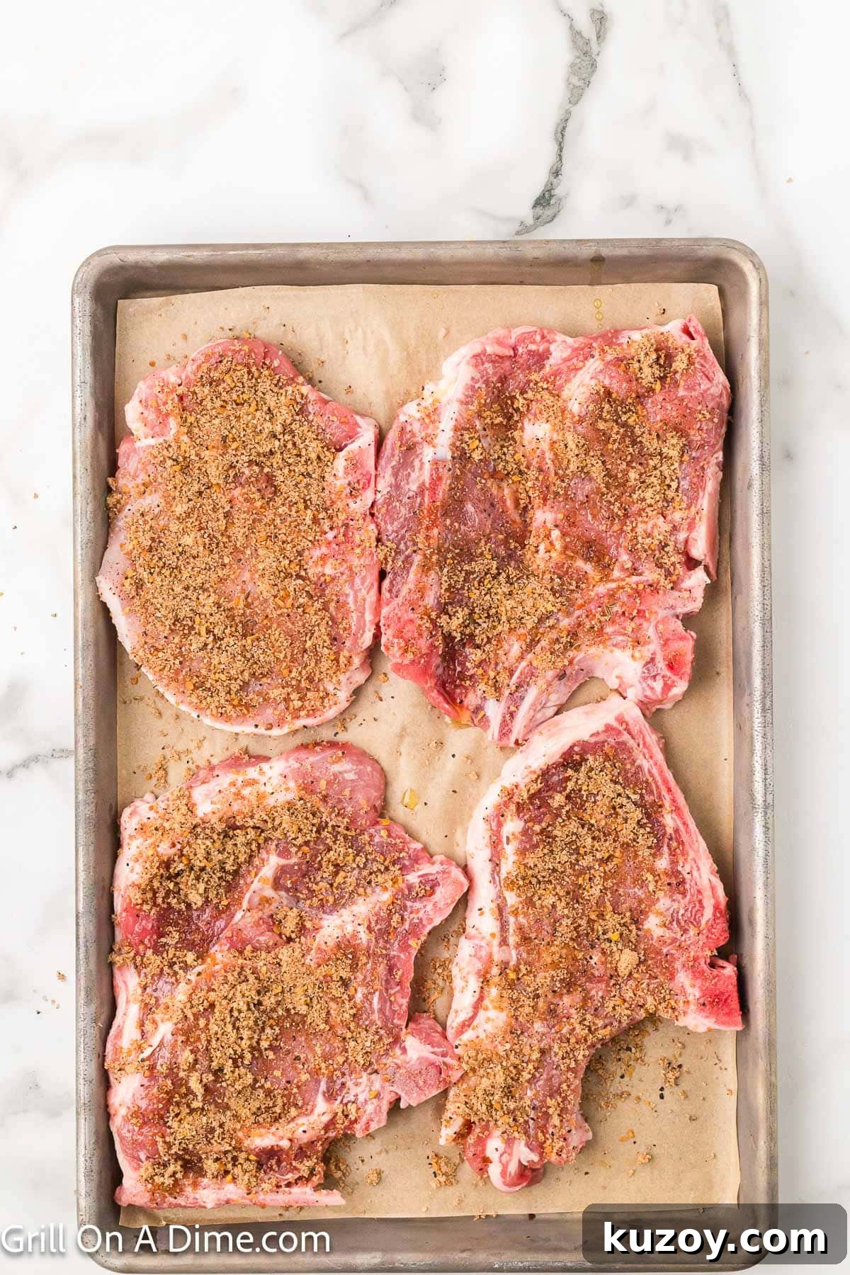 Spicy Honey-Glazed Pork Chops Recipe 5 Adding seasoning mix to pork chops on a baking sheet lined with parchment paper