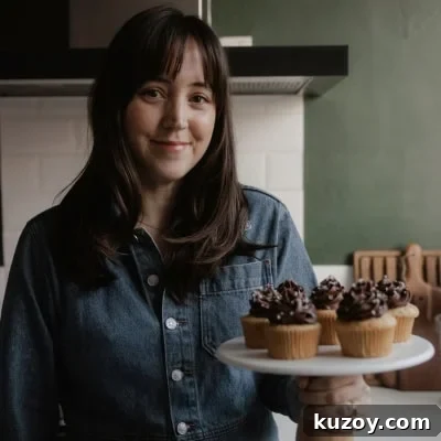Double-Ginger Shortbread Cookies: Chewy Ginger & Crystallized Chip Recipe 16 Ella from Alpine Ella is holding a cake stand with cupcakes on it.