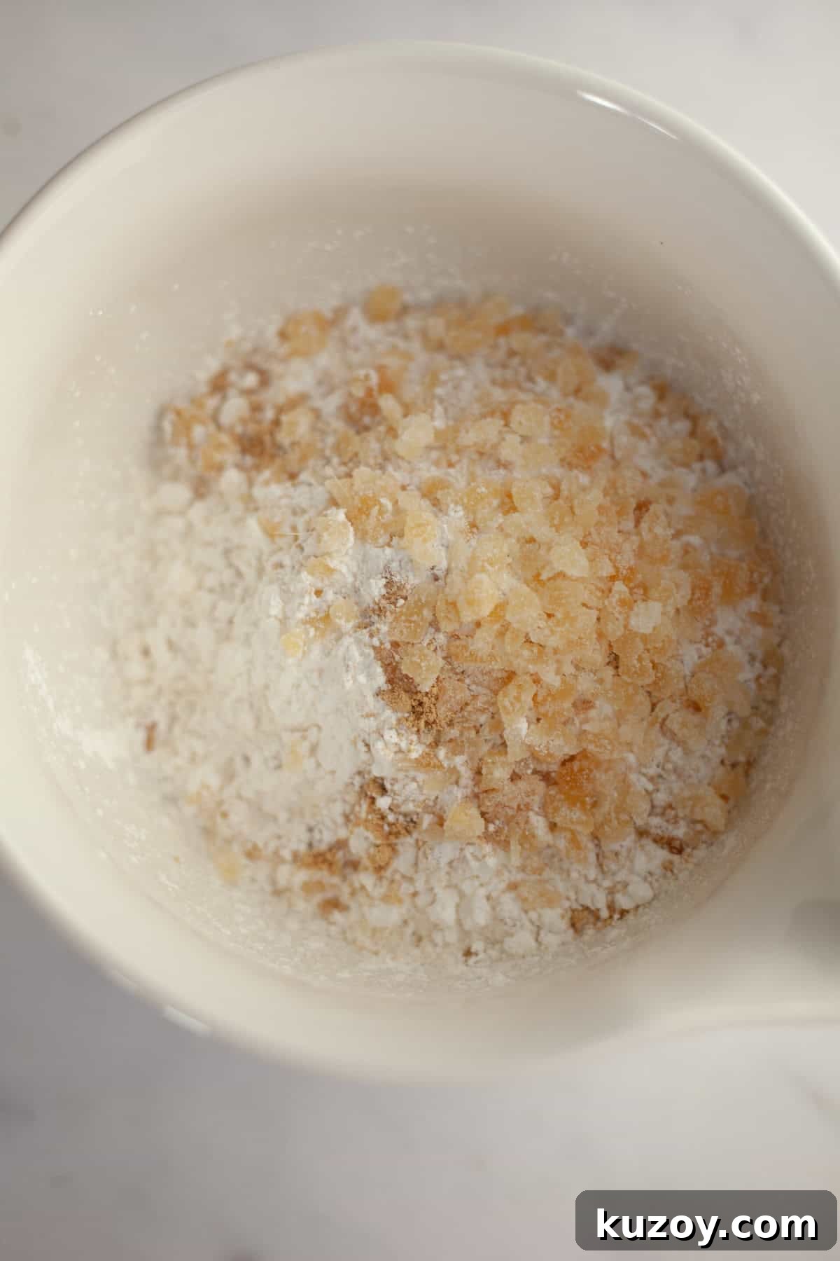 Double-Ginger Shortbread Cookies: Chewy Ginger & Crystallized Chip Recipe 5 A white bowl with flour and chopped crystallized ginger.