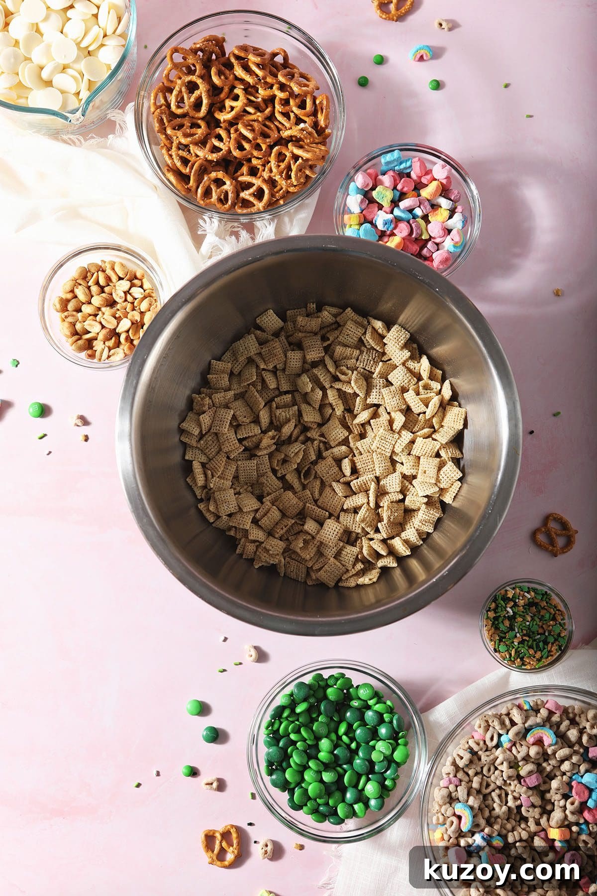St. Patrick’s Day Snack Mix Recipe for Festive Parties 3 Ingredients for a St. Patrick's Day Snack Mix in bowls on a pink countertop