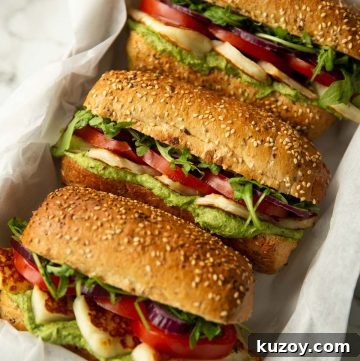 3 halloumi sandwiches in large white dish on marble background