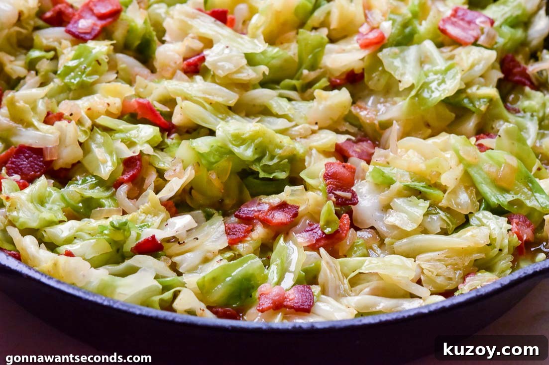 fried cabbage with bacon and onions in a cast iron skillet