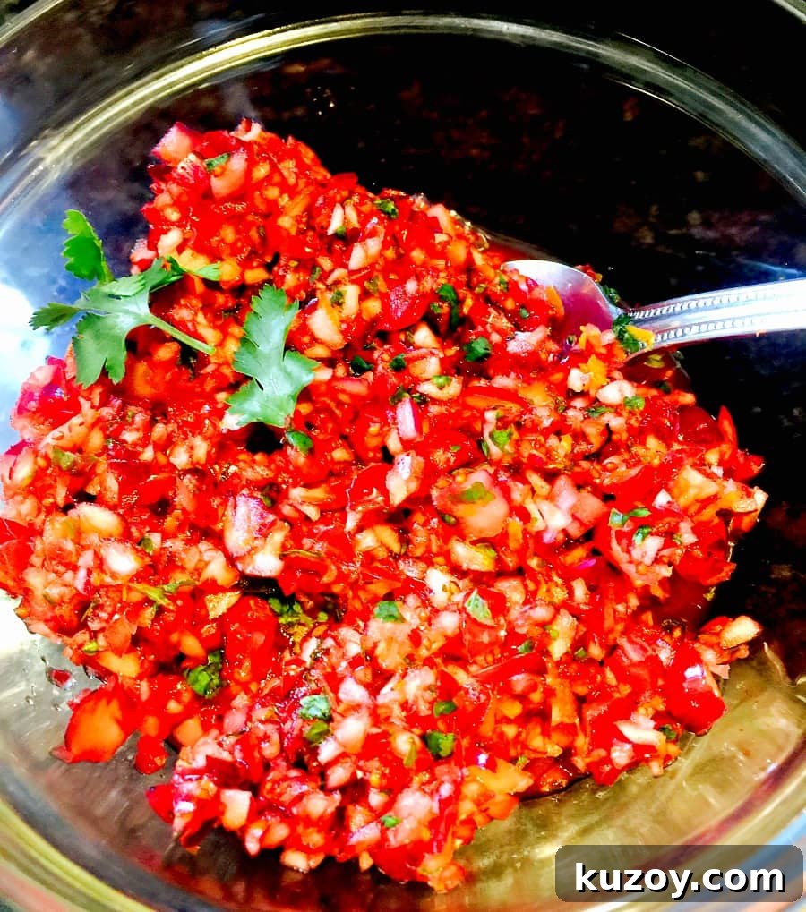 Festive Cranberry Salsa Recipe for Holiday Entertaining 4 Finished Cranberry Salsa in a glass bowl with a serving spoon