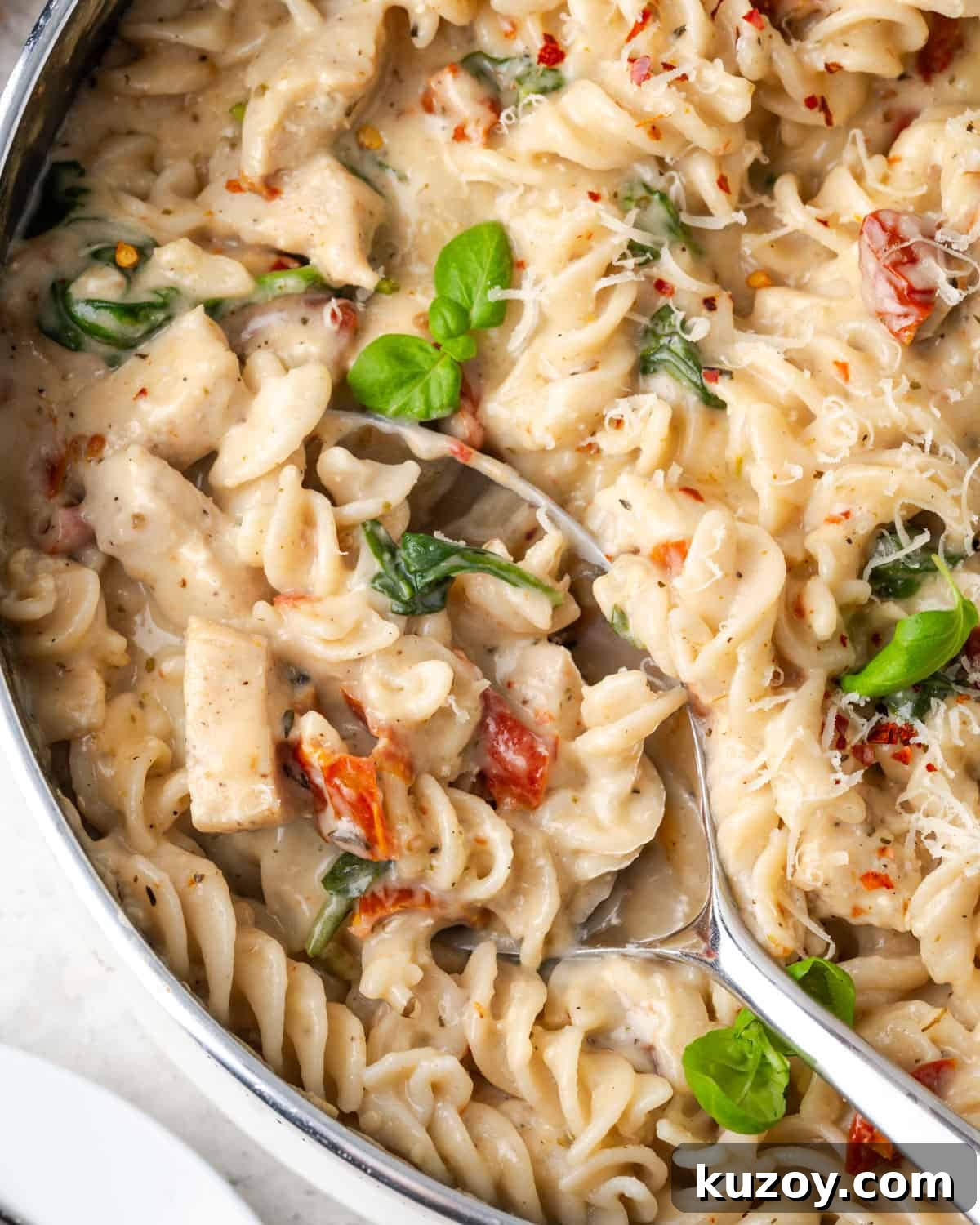 30-Minute Marry Me Chicken Pasta Recipe for Date Night 2 A spoon scooping out a portion of marry me chicken pasta.