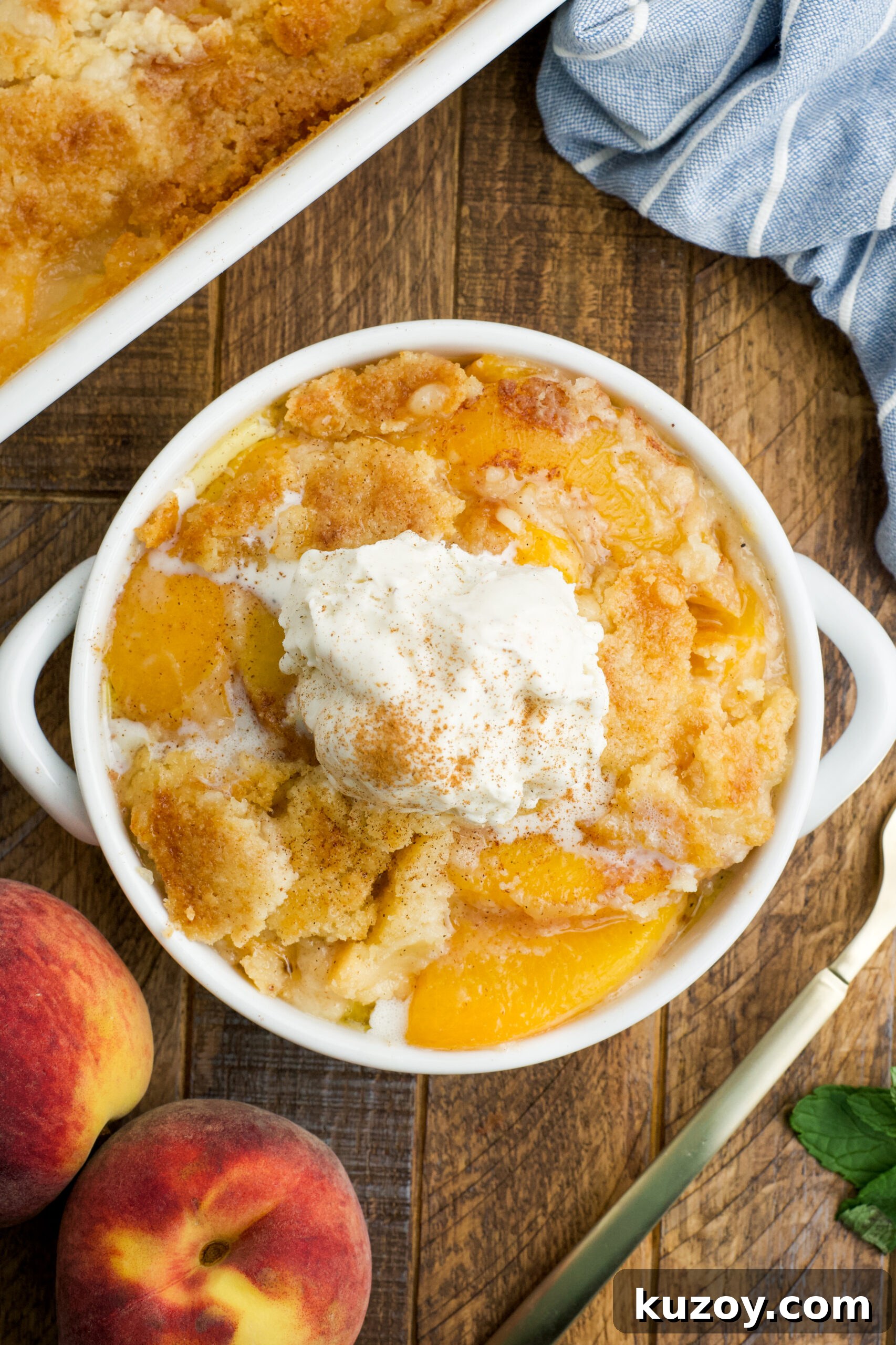No-Bake Peach Dump Cake Recipe for Quick Summer Dessert 15 Overhead view of a serving of Peach Dump Cake in a white bowl topped with a scoop of vanilla ice cream.