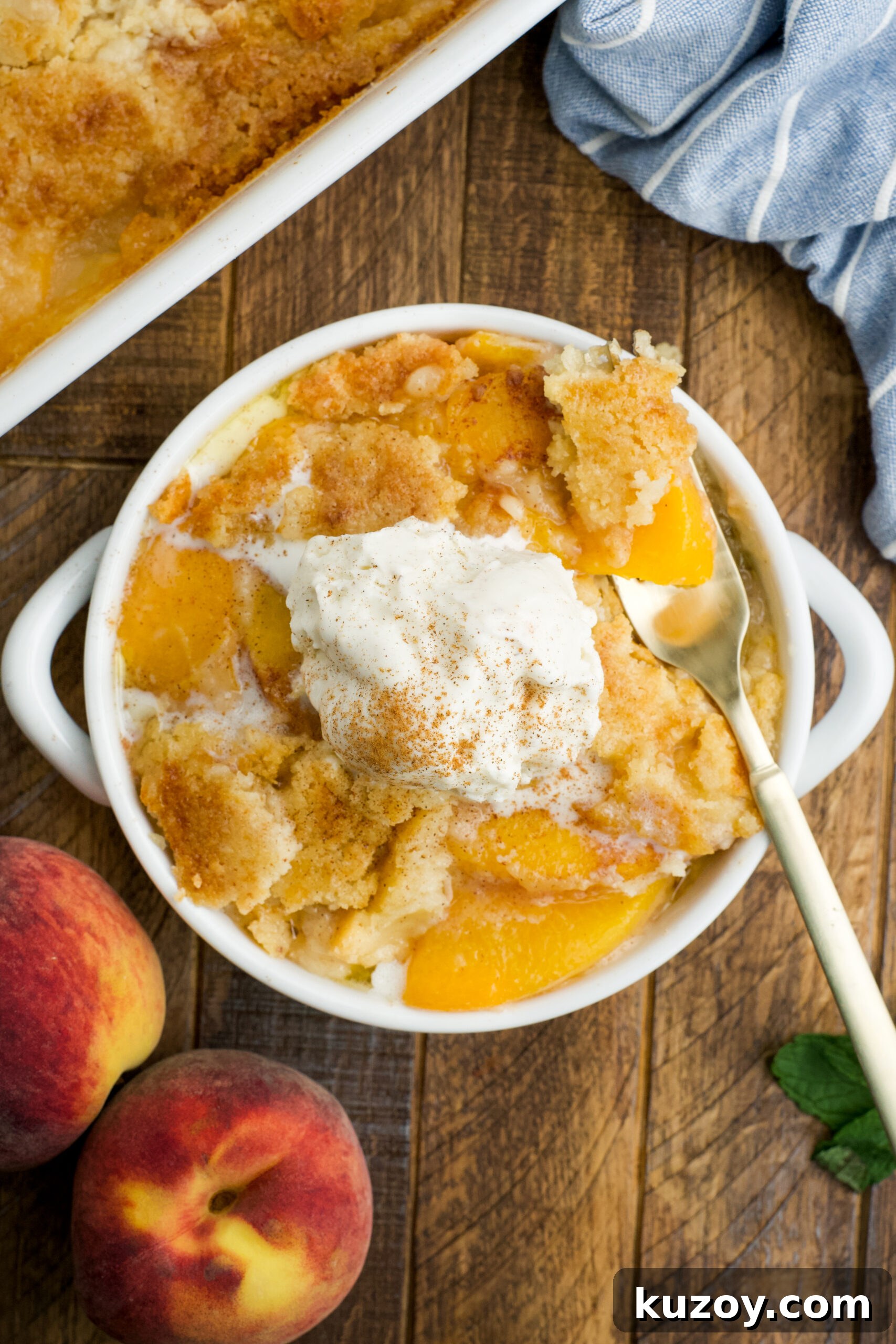 No-Bake Peach Dump Cake Recipe for Quick Summer Dessert 17 Overhead view of a serving of Peach Dump Cake in a white bowl topped with a scoop of vanilla ice cream.