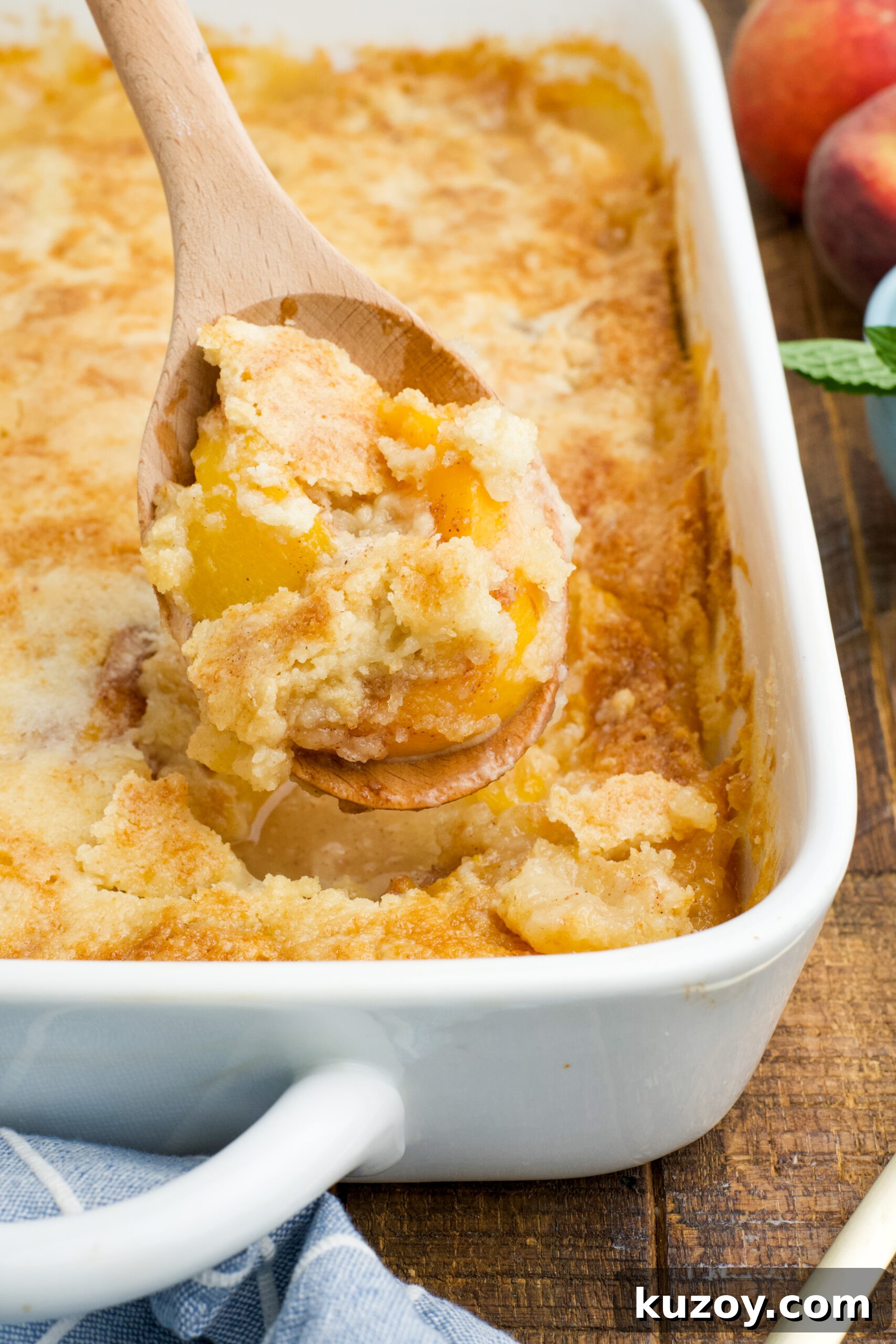 No-Bake Peach Dump Cake Recipe for Quick Summer Dessert 3 Close up view of a wooden spoon with a spoonful of Peach Dump Cake.