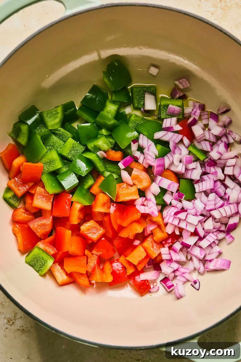Hearty Butternut Squash & White Bean Chili Recipe 4 Red onion and bell peppers in dutch oven pot being sautéed.
