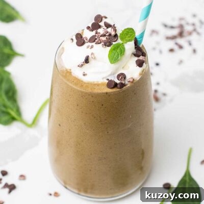 A green smoothie with coffee and chocolate shown garnished with whipped cream.