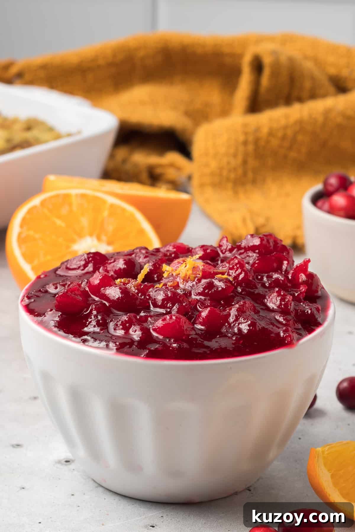 Citrus Cranberry Sauce Recipe: Orange-Infused Holiday Cranberry Sauce 3 A white bowl filled with cranberry sauce topped with a little orange zest.