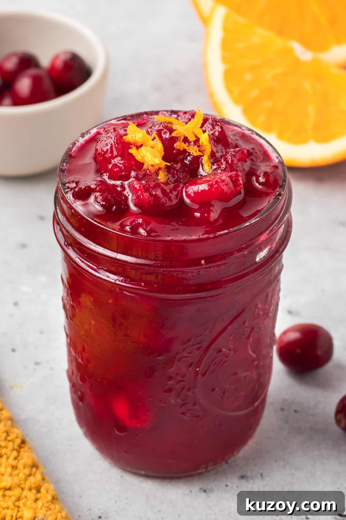 Citrus Cranberry Sauce Recipe: Orange-Infused Holiday Cranberry Sauce 7 A small mason jar filled with cranberry sauce and topped with orange zest.
