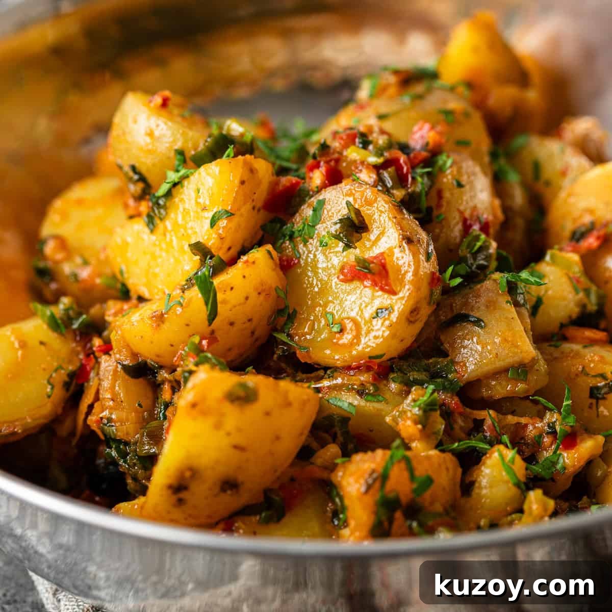 closeup: pan fried calabrian potatoes with chilies and herbs in a metal bowl