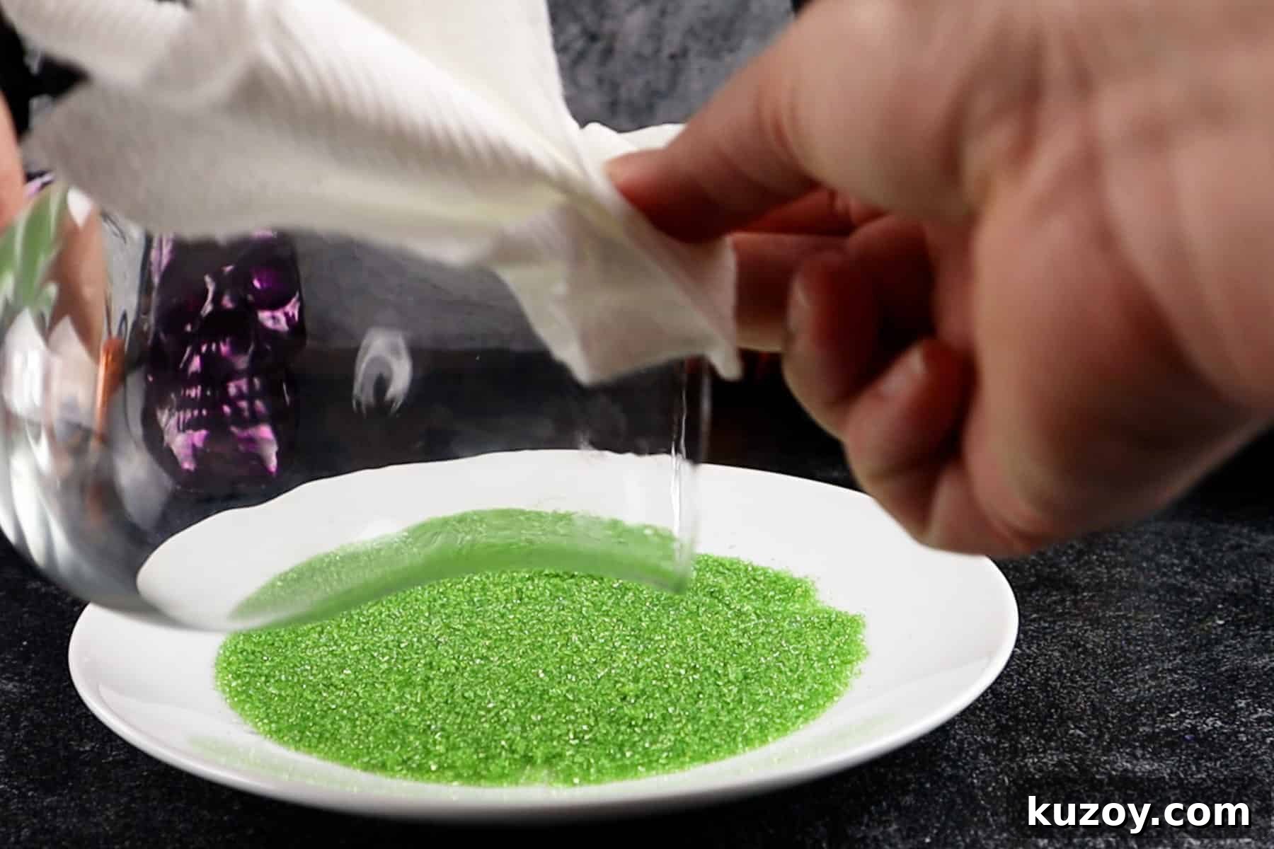 Spooky Cauldron Cocktail Recipe for Halloween Parties 5 wiping the rim of a glass with sugary liquid