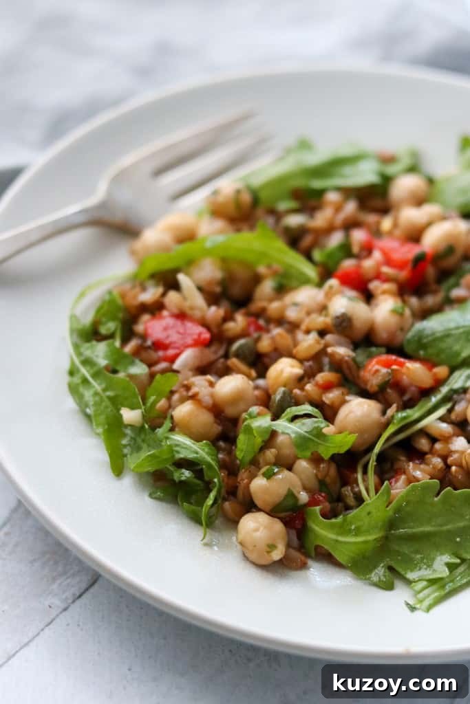Rye Berry Salad with Chickpeas, Roasted Red Peppers & Arugula 8 Rye berry and chickpea salad on a plate with a fork