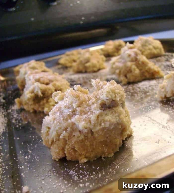 Image shows a close up of an uncooked ball of cookie dough on a cookie sheet