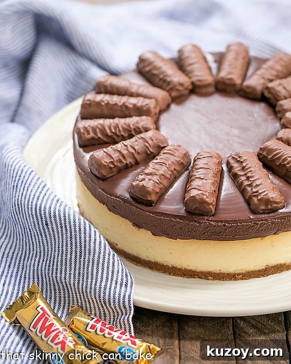 Twix Cheesecake - A dream cheesecake for chocolate and caramel lovers! Twix Cheesecake on serving plate.