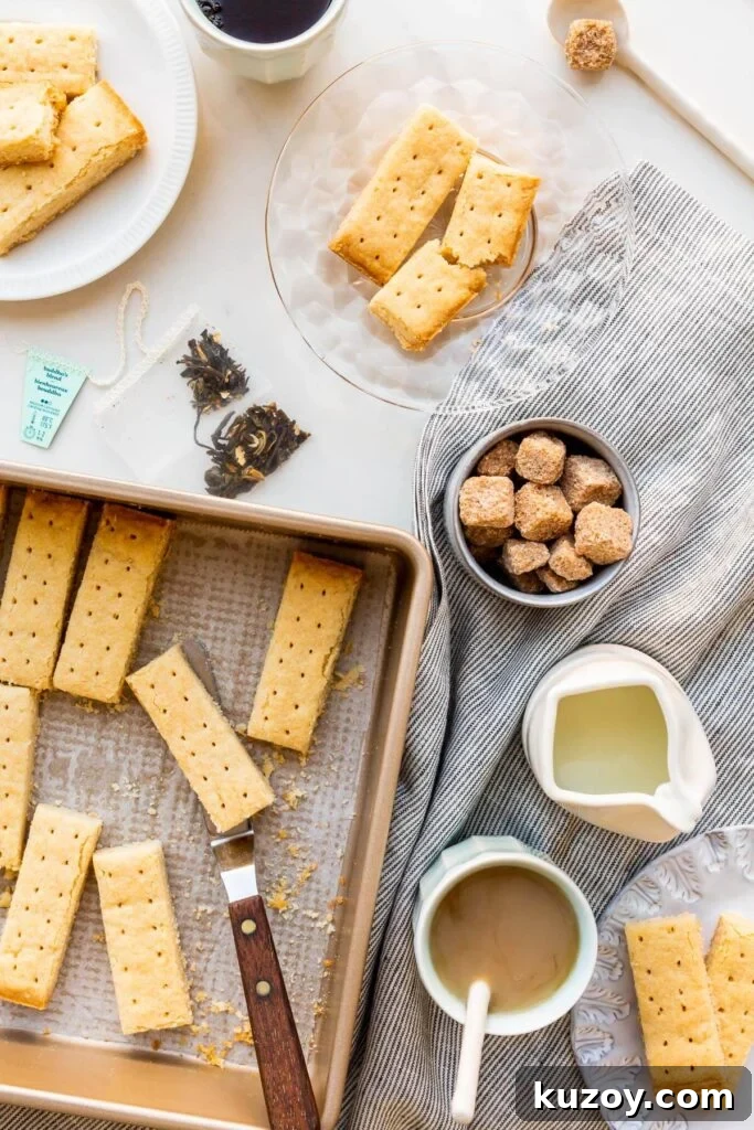 Simple 1-2-3 Shortbread Cookies Recipe for Perfect Crunch 2 Shortbread cookies being served on small plates with cups of tea, milk, and sugar cubes.