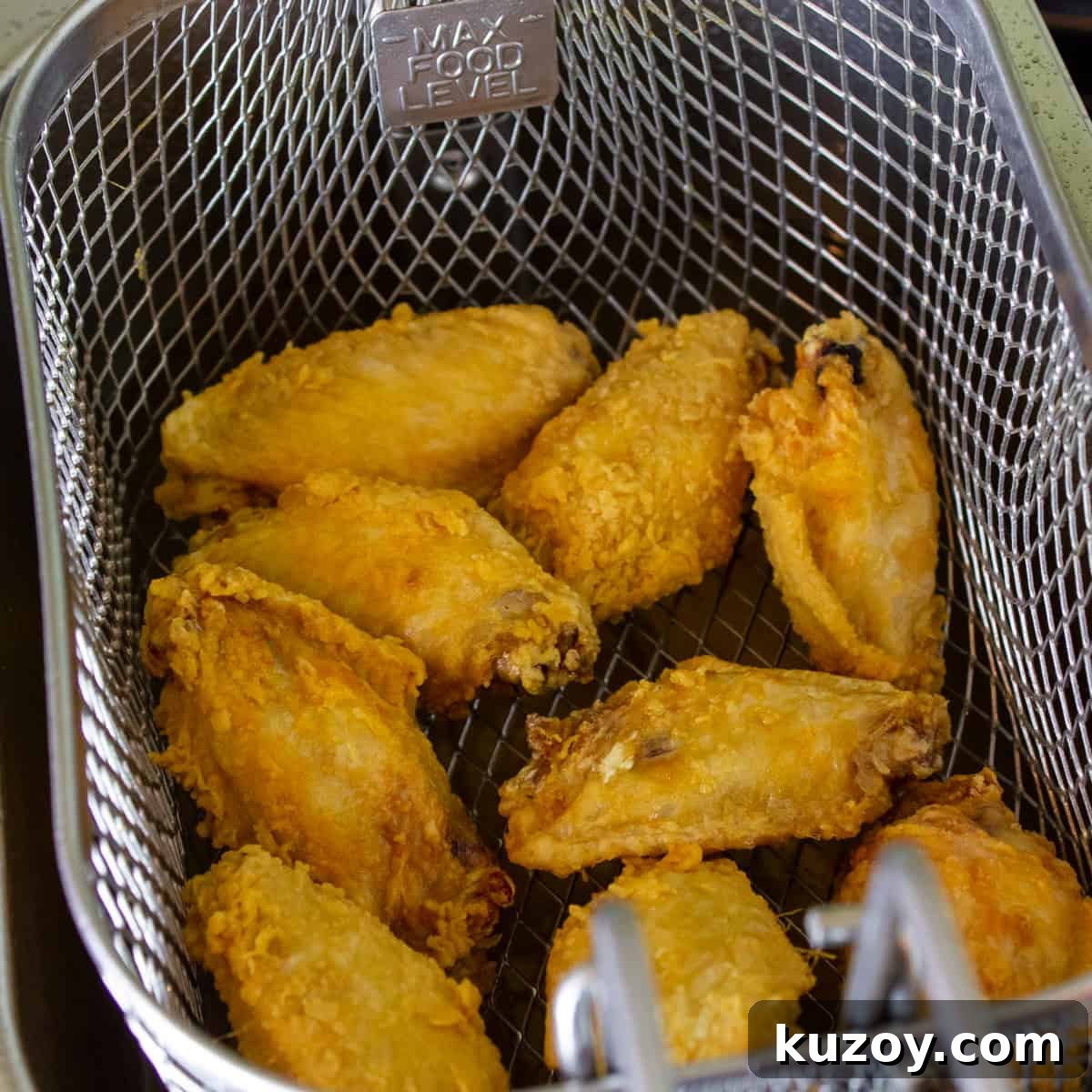 Sticky Honey Garlic Chicken Wings Recipe (Crispy & Flavorful) 7 Wings out of the fryer and draining in the basket.