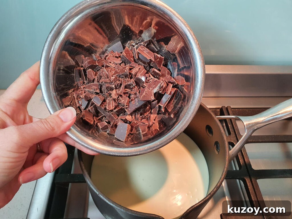 adding chocolate to pot on stove with chocolate fudge sauce ingredients.