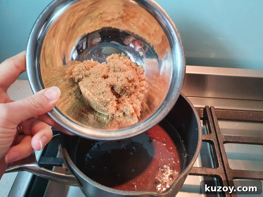 adding brown sugar to pot on stove with chocolate fudge sauce ingredients.