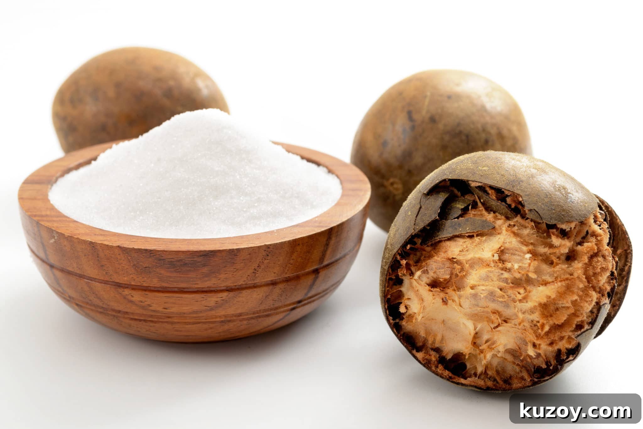 Monk Fruit Guide: Uses, Benefits, Risks, and How to Use 2 A wooden bowl filled with white granulated monk fruit sweetener, with an open monk fruit sitting beside the bowl