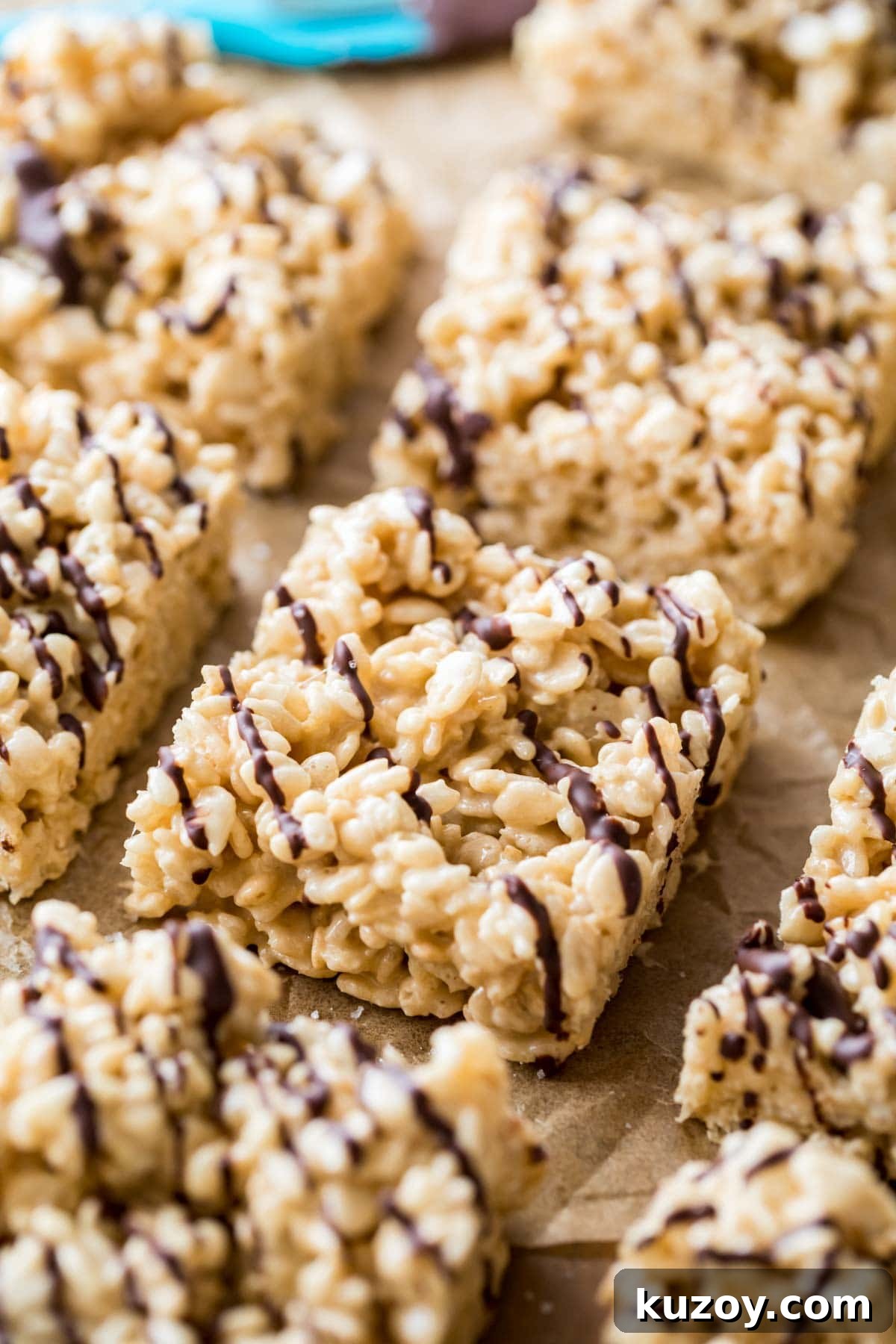 Close-up shot of salted caramel rice krispie treats lightly drizzled with dark chocolate.