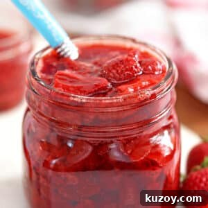 How to Make Smooth Homemade Caramel Sauce for Desserts 6 Glass jar of Strawberry Sauce with blue spoon sticking out.