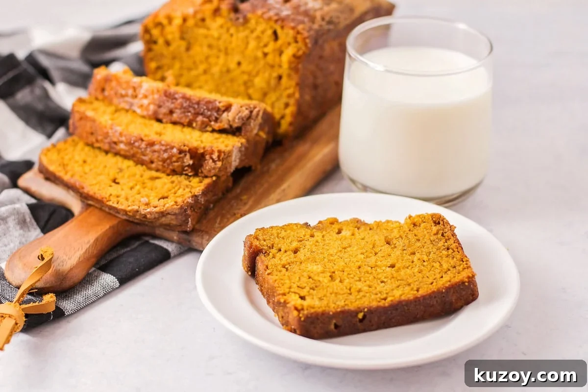 Deliciously tender, easy pumpkin bread is topped with cinnamon and sugar for a family-favorite fall treat you can enjoy on repeat. Slices of easy pumpkin bread on a plate and cutting board.