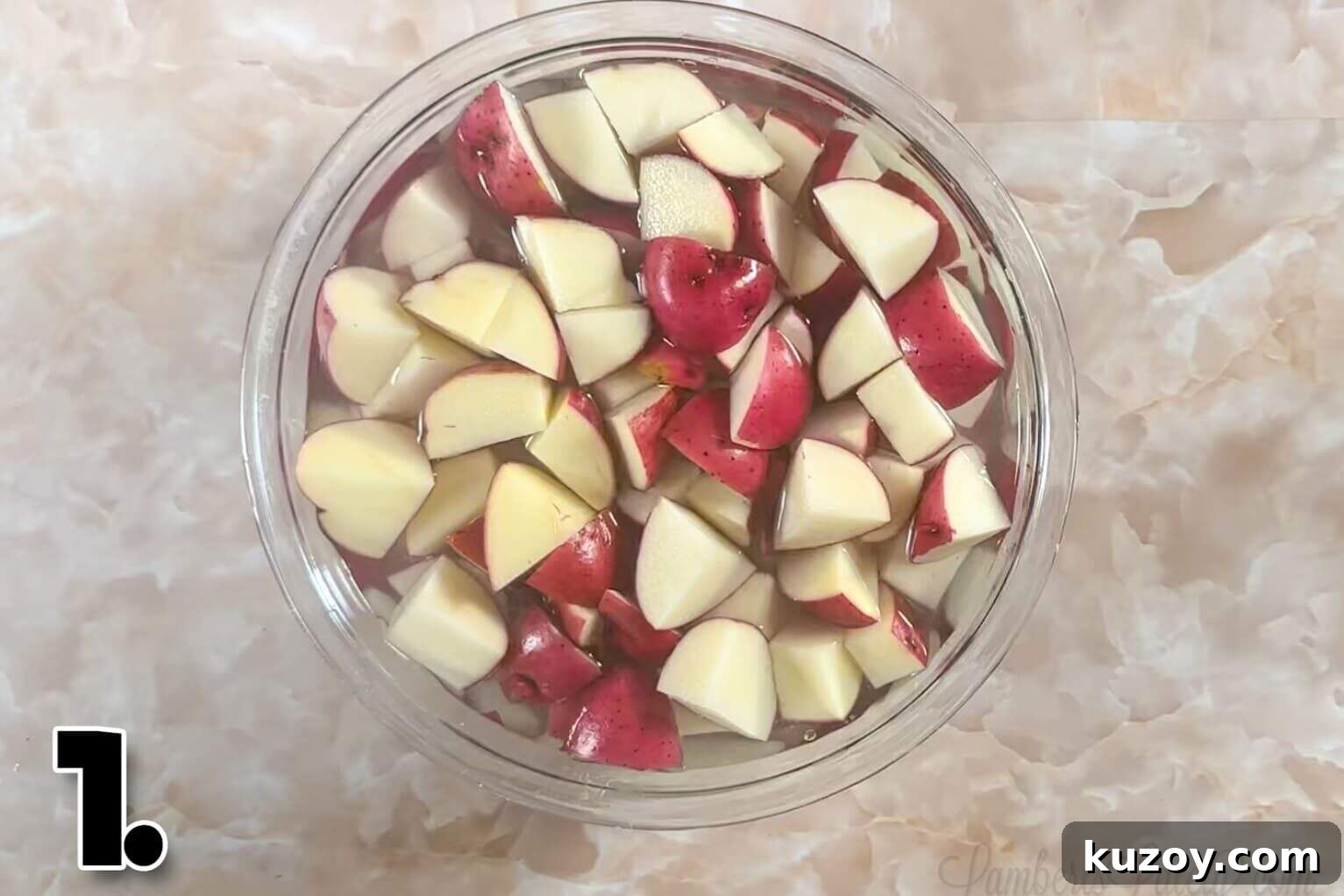 red potatoes, cut into pieces, in a bowl of water.