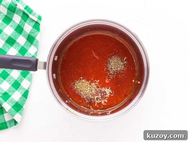 Homemade Pizza Sauce Without Tomato Paste — Fresh & Flavorful 5 Tomato sauce and spices in a saucepan.