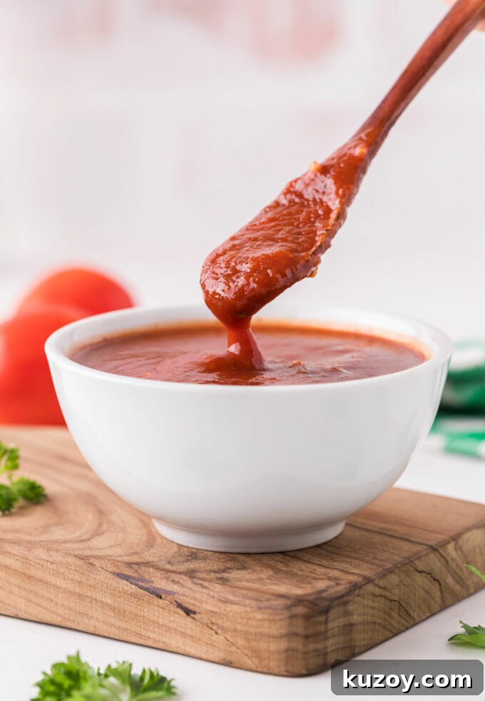 Homemade Pizza Sauce Without Tomato Paste — Fresh & Flavorful 6 Spooning pizza sauce out of a bowl.