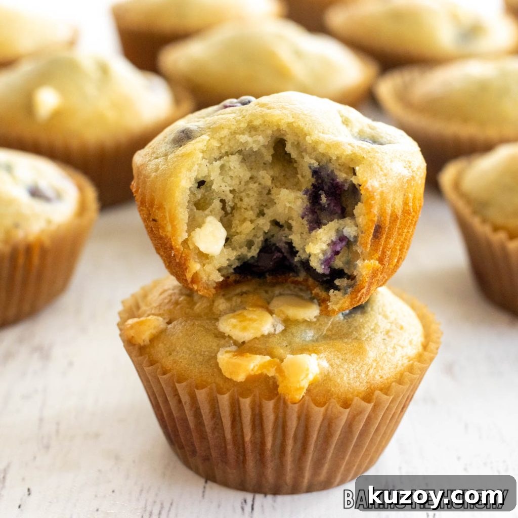 blueberry white chocolate muffins missing a bite stacked