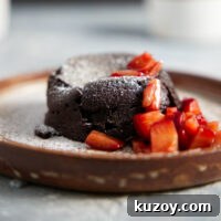 Air Fryer Chocolate Lava Mug Cake Recipe 24 Air fryer mug cake plated with chopped strawberries and dusted with powdered sugar.