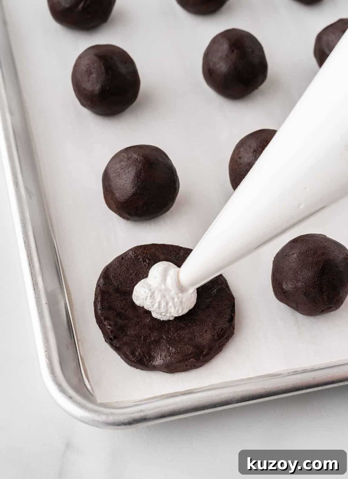 piping marshmallow fluff inside oreo truffle ball