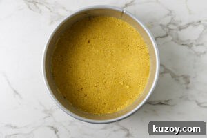 Pressing cookie crumbs into the bottom of a spring form pan.