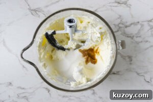 Adding sugar and vanilla to the cream cheese mixture.