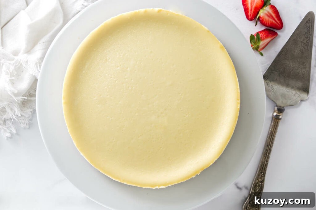 A perfectly smooth cheesecake on a plate showing no cracks.