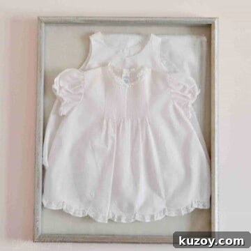 pink baby dress in a shadow box on a wall.