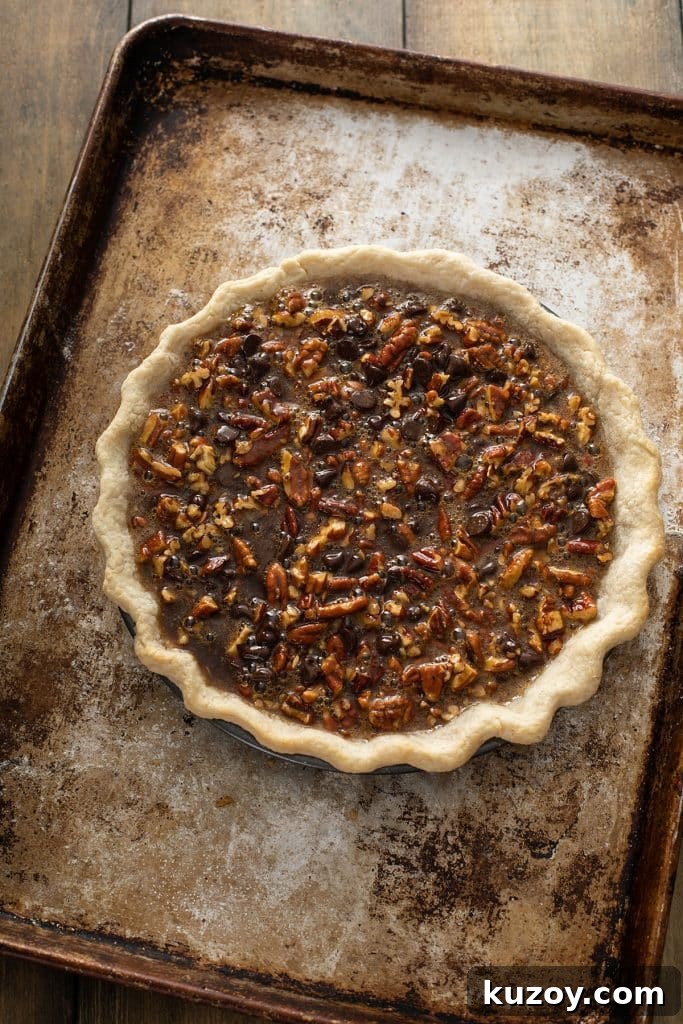Decadent Chocolate Pecan Pie with Gooey Filling 10 Chocolate Pecan pie on a baking dish ready to bake.