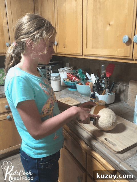 tween girl cutting cantaloupe