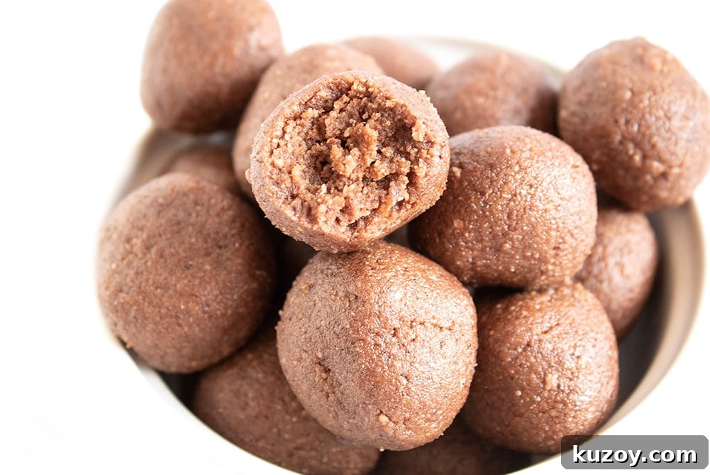 Caffeinated Keto Chocolate Coffee Fat Bombs for Energy 3 closeup of keto chocolate fat bombs in a bowl with piece missing from one